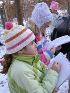 A group of children sketching in their nature journals - Photo by Drew Monkman 